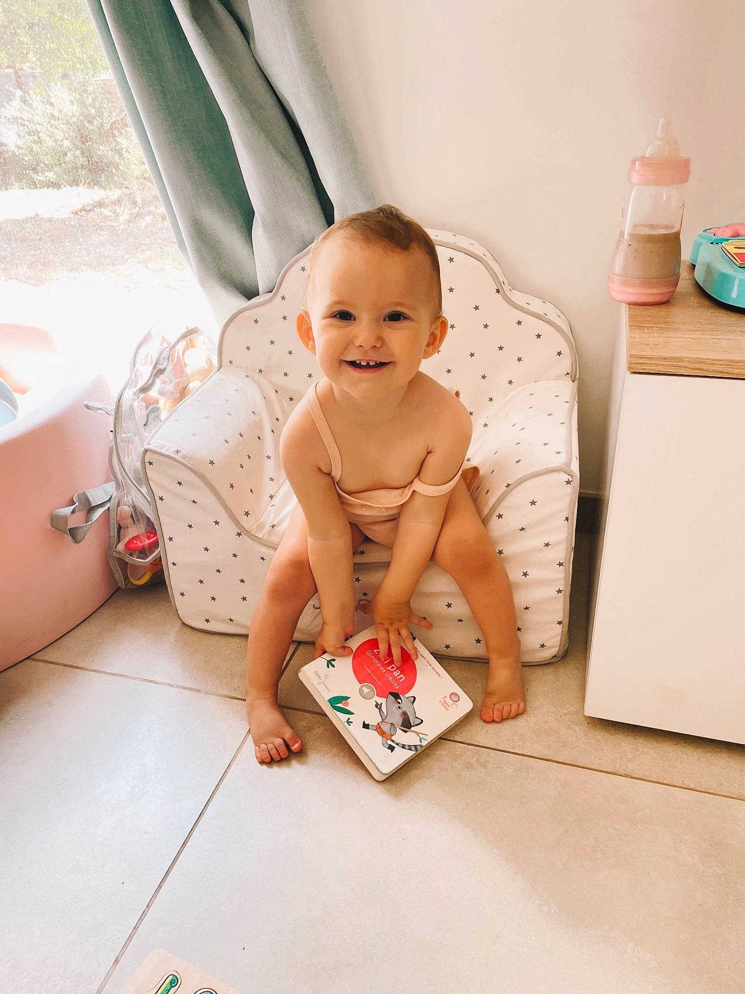 Romy participe au concours pour gagner de l'argent avec cette photo : baby, barefoot, bathing, chest, child, comfort, facial_expression, floor, flooring, foot, fun, hairstyle, happy, human_leg, joy, person, room, sitting, skin, smile