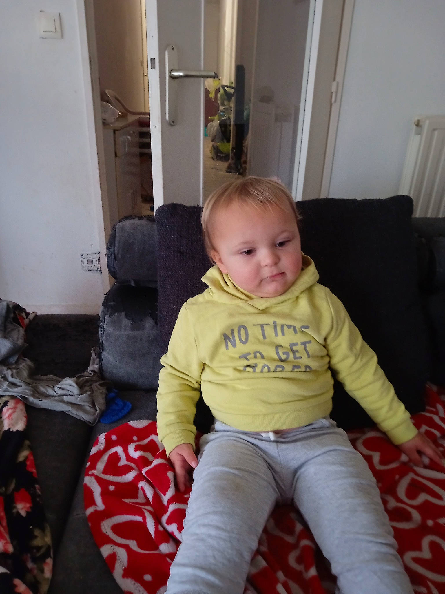 John participe au concours pour gagner de l'argent avec cette photo : baby, baby_toddler_clothing, chair, cheek, child, comfort, couch, door, flooring, fun, human_body, knee, lap, living_room, person, room, sitting, smile, thigh, toddler