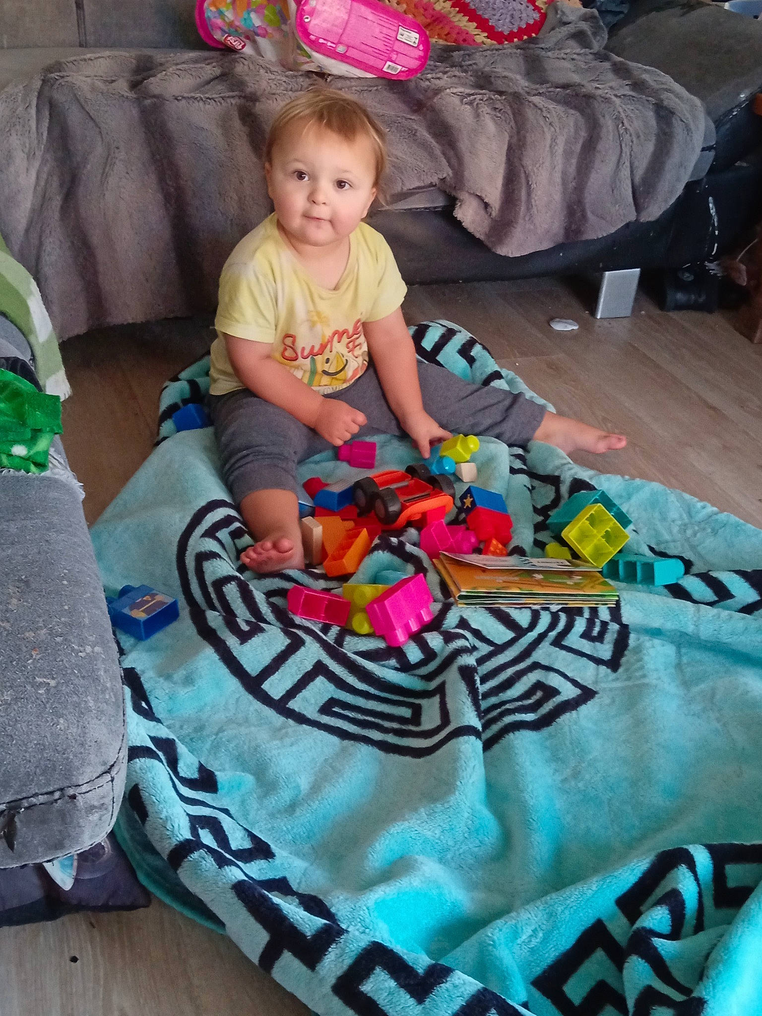 John participe au concours pour gagner de l'argent avec cette photo : baby, baby_toddler_clothing, child, comfort, event, flooring, fun, green, leisure, linens, magenta, mammal, people, person, pink, play, room, sitting, t_shirt, toddler