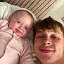 Mabel is registered to the contest to win money with this photo: baby, bed, blanket, candid, casual, child, clothing, cozy, face, family, happy, indoor, person, portrait, relaxing, smile, striped, together, wooden_wall, young_adult