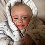Mabel is registered to the contest to win money with this photo: baby, infant, smiling, face, robe, fluffy, hand, cozy, cushion, blanket, star_pattern, clothing, indoors, happy, cute, skin, portrait, child, young, comfort