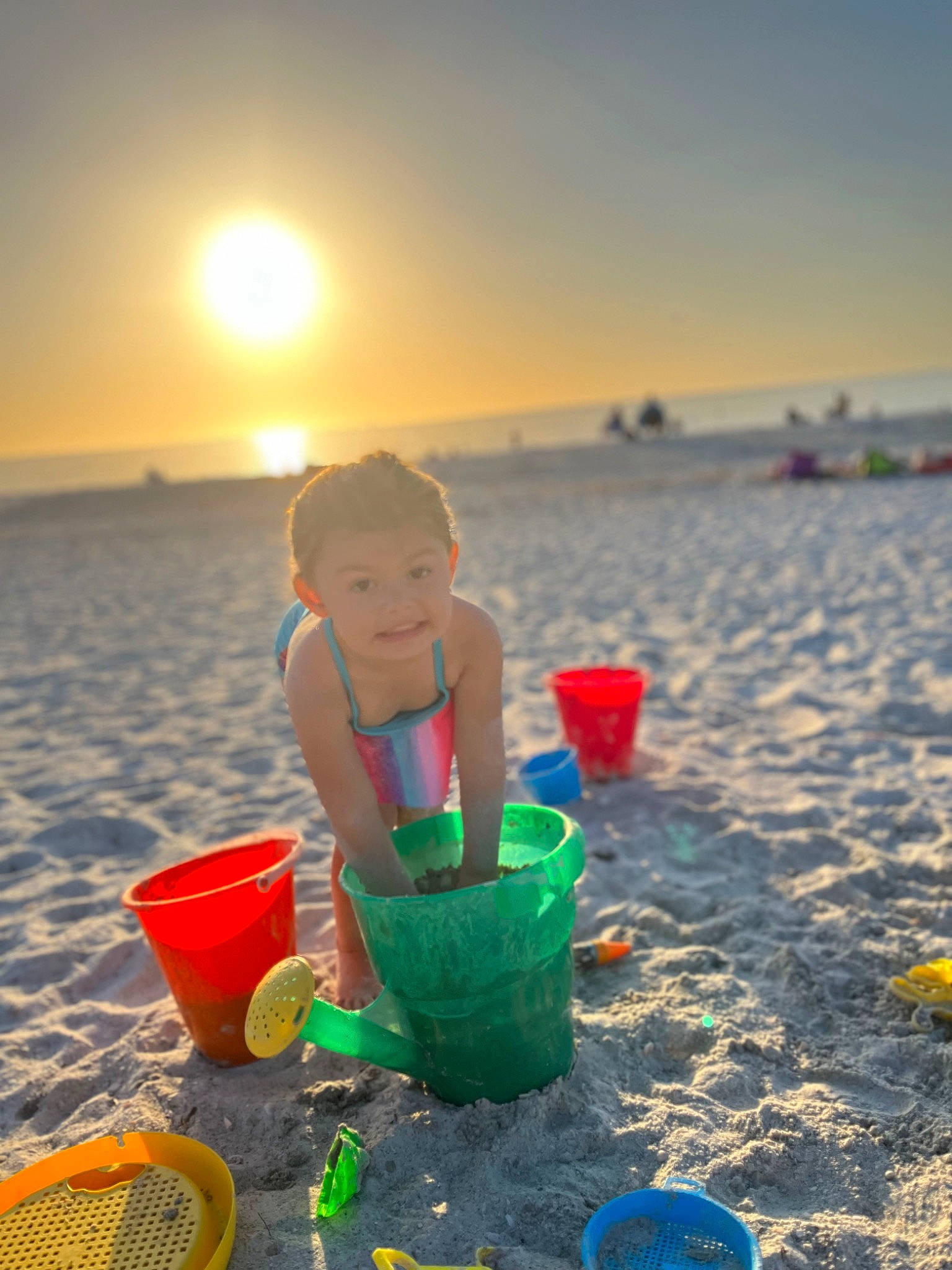 Calie is registered to the contest to win money with this photo: baby, beach, bucket, child, fun, happy, horizon, joy, leisure, light, morning, people_in_nature, people_on_beach, person, recreation, sand, sky, summer, sunlight, sunset