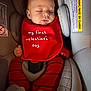Eziah is registered to the contest to win money with this photo: infant, baby, sleeping, closed_eyes, bib, red_bib, car_seat, seatbelt, safety_label, warning_label, socks, striped_pants, hand, face, cozy, cute, peaceful, padded, newborn, portrait