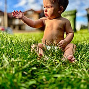 Zion joined the competition — help win amazing prizes! baby, child, toddler, sitting, grass, outdoor, portrait, sunlight, sky, clouds, neighborhood, house, nature, barefoot, curious, serious_expression, hand_gesture, short_hair, infant, photography