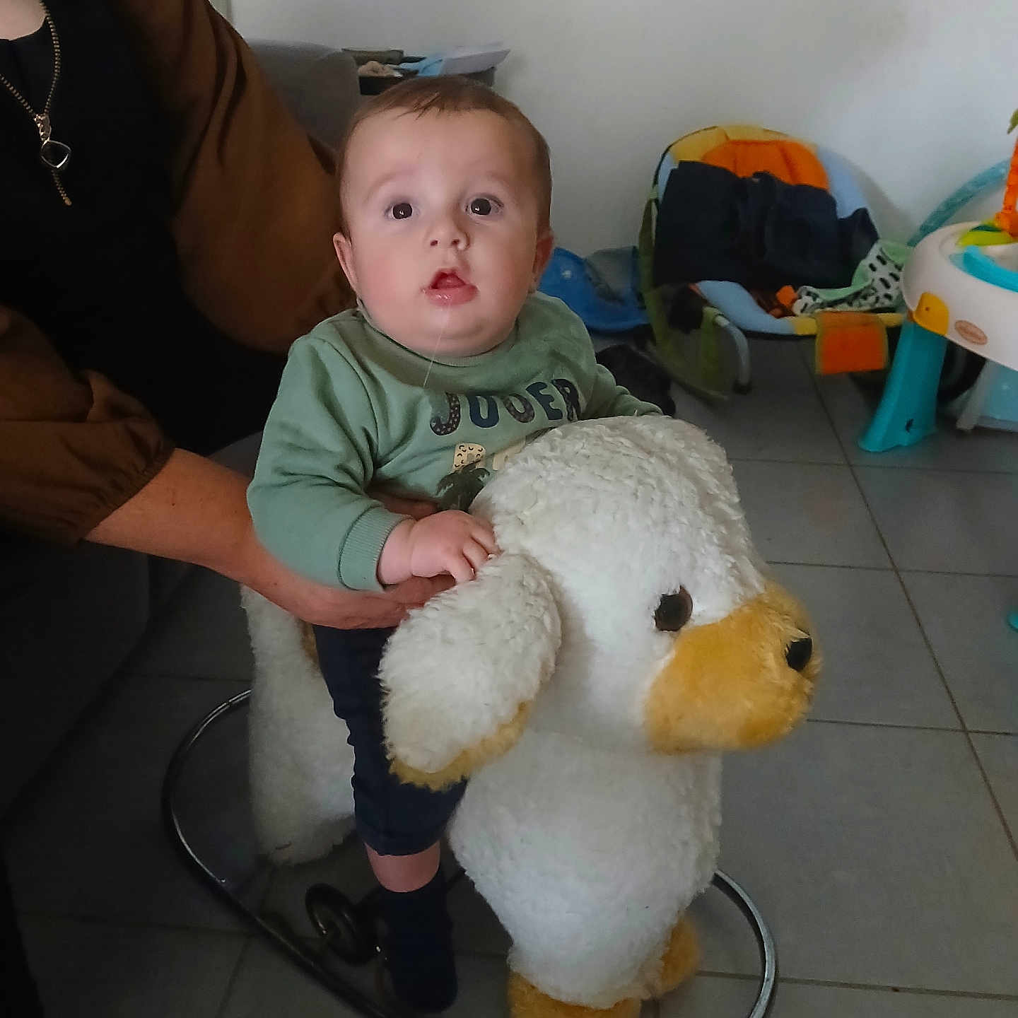 Raphaël participe au concours pour gagner de l'argent avec cette photo : adult, baby, child, childcare, clothing, cushion, expression, floor, footwear, furniture, hand, indoor, person, play, rocking_toy, seat, stuffed_animal, support, toy, window