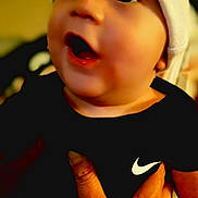 Liam joined the competition — help win amazing prizes! apparel, baby, beanie, black_clothing, child, closeup, cute, expression, face, hand, happy, headwear, holding, indoor, infant, nike, person, portrait, skin, smiling