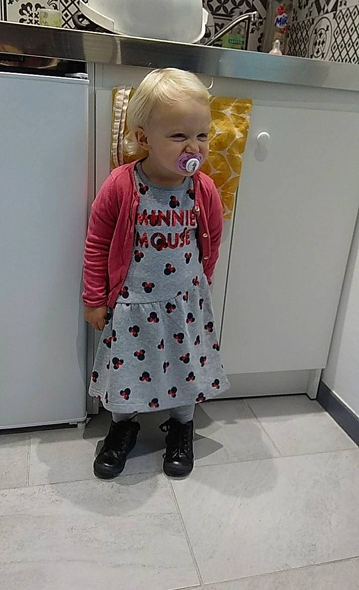 Louna a rejoint le concours — aidez-le/la à gagner de superbes lots ! baby, baby_products, baby_toddler_clothing, child, dress, fashion_design, floor, flooring, foot, human_leg, joint, knee, one_piece_garment, pattern, person, refrigerator, room, sleeve, smile, street_fashion