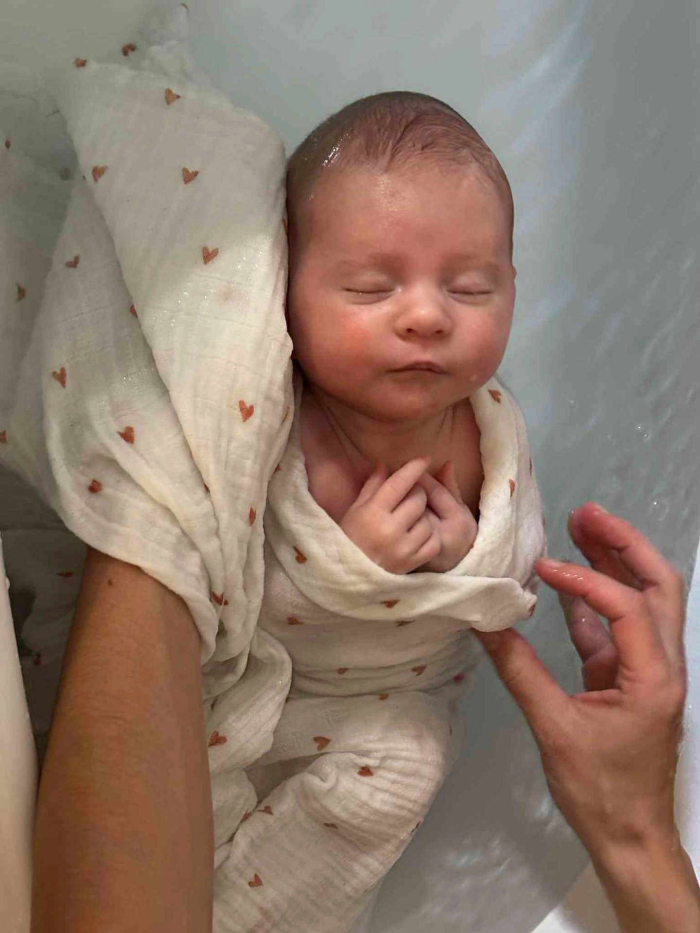 Norah participe au concours pour gagner de l'argent avec cette photo : baby, newborn, blanket, heart_pattern, bath, water, hand, skin, sleeping, wrapped, soft, infant, peaceful, tender, care, closeup, person, human, rest, comfort