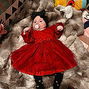 Norah a rejoint le concours — aidez-le/la à gagner de superbes lots ! baby, red_dress, black_headband, pacifier, fluffy_blanket, crib, soft_toys, heart_pattern, infant, lying_down, toddler, cozy, child, cute, indoor, blanket, clothing, person, baby_toys, furniture