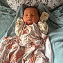 newborn, baby, sleeping, blanket, animal_print, pillow, bed, cozy, soft, infant, cute, peaceful, wrapped, fabric, textured, resting, child, indoors, portrait, comfort
