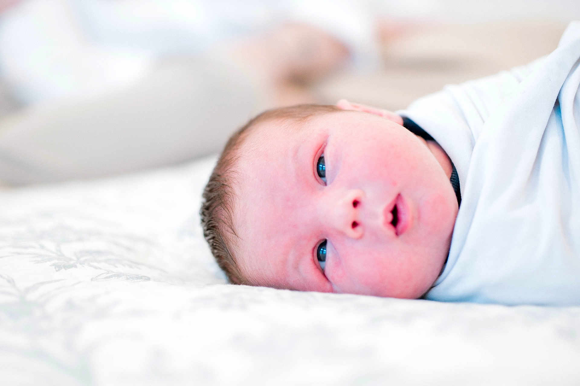 Casey joined the competition — help win amazing prizes! newborn, baby, infant, face, eyes, blanket, white, swaddle, lying_down, closeup, soft_light, portrait, sleeping_area, skin, head, cute, child, indoors, resting, young