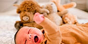 Casey joined the competition — help win amazing prizes! baby, infant, sleepy, yawning, bed, blanket, stuffed_animal, toy, cozy, clothing, hand, face, mouth, skin, person, indoor, closeup, lying_down, soft, cute