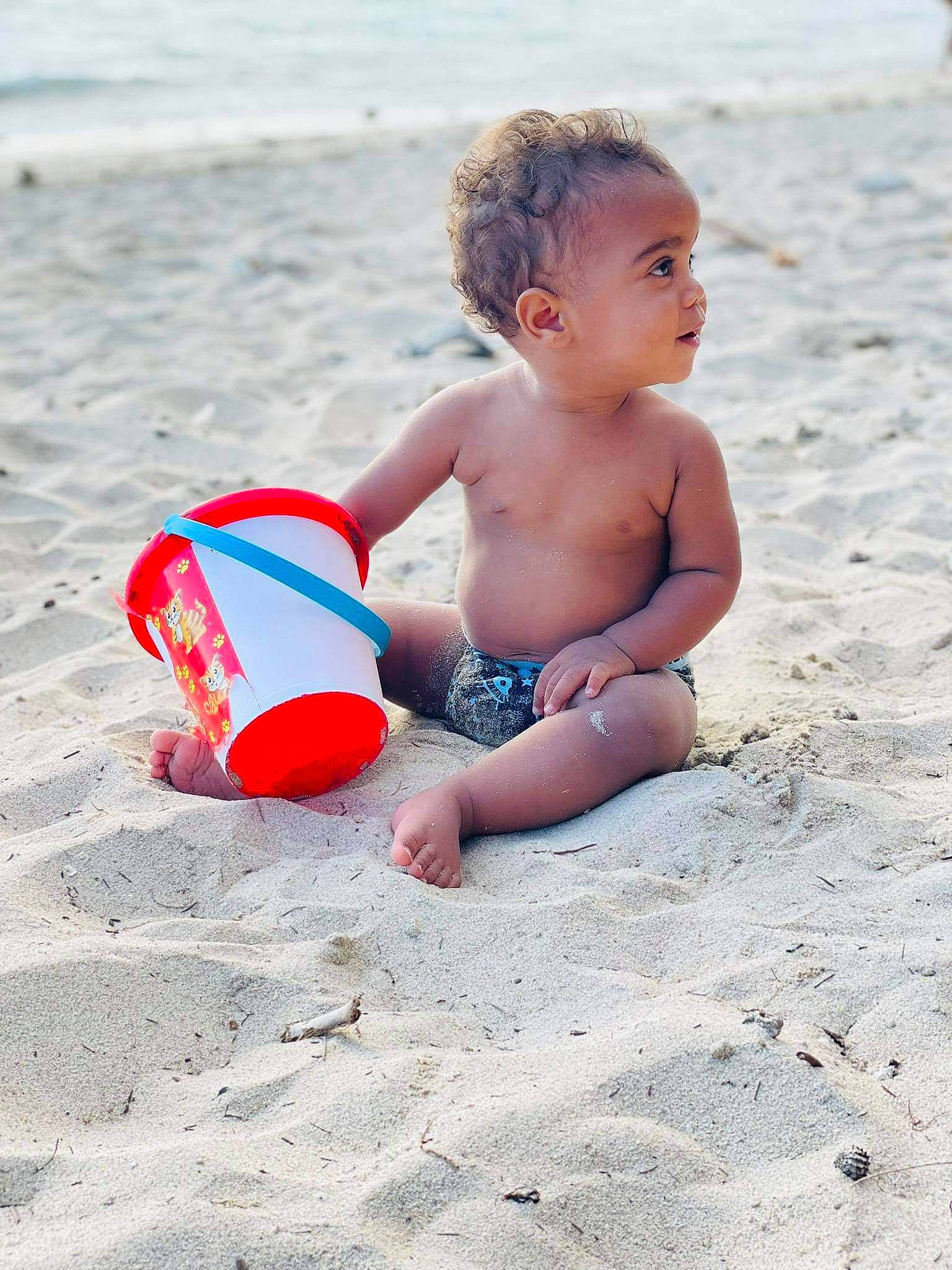 Mathéo a rejoint le concours — aidez-le/la à gagner de superbes lots ! baby, barechested, barefoot, beach, chest, coast, foot, fun, happy, human_body, human_leg, leisure, people_in_nature, people_on_beach, person, recreation, sand, shore, sitting, toddler