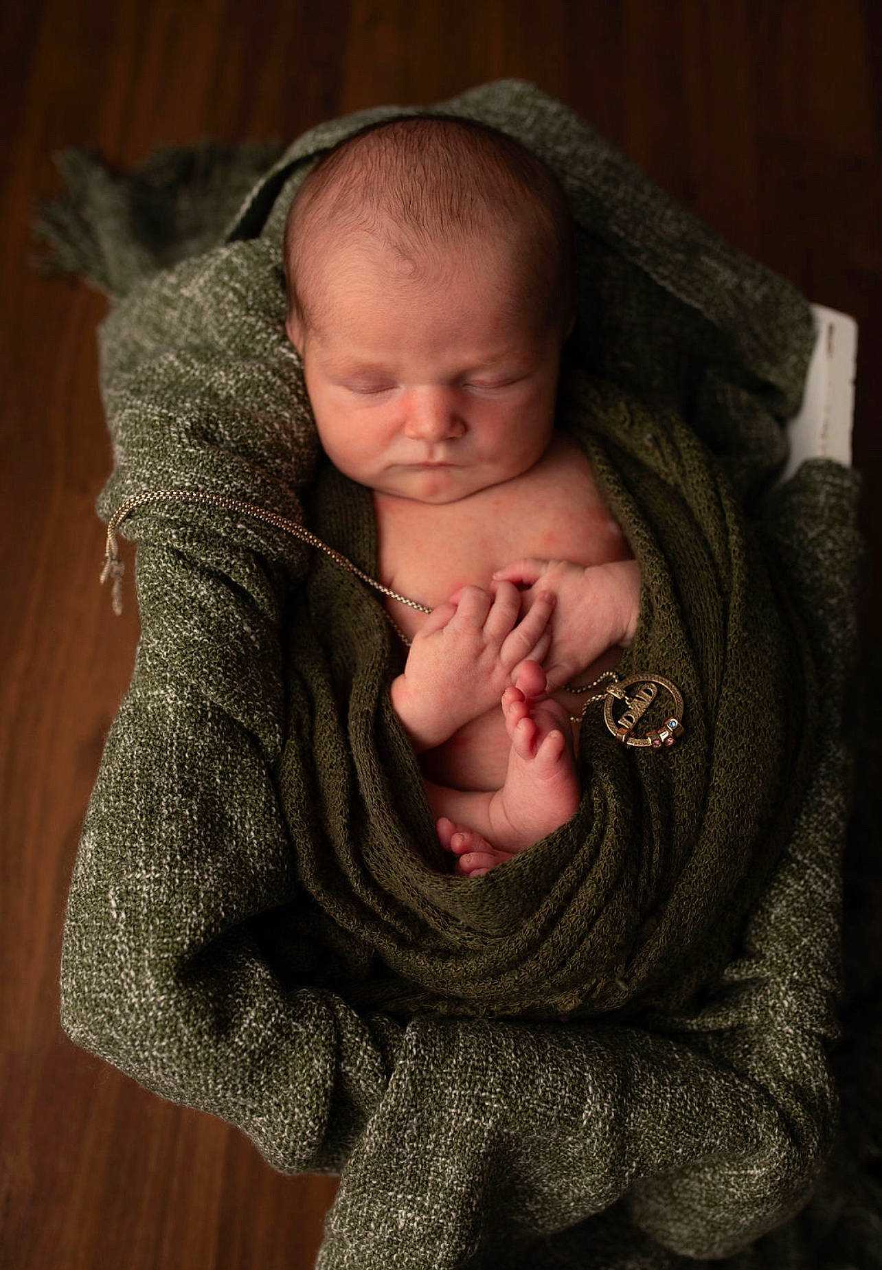 Zealand is registered to the contest to win money with this photo: baby, baby_toddler_clothing, cheek, child, comfort, eye, gesture, grey, hand, human_body, mammal, nose, person, sitting, sleeve, thumb, toddler, vertebrate, wood, wool