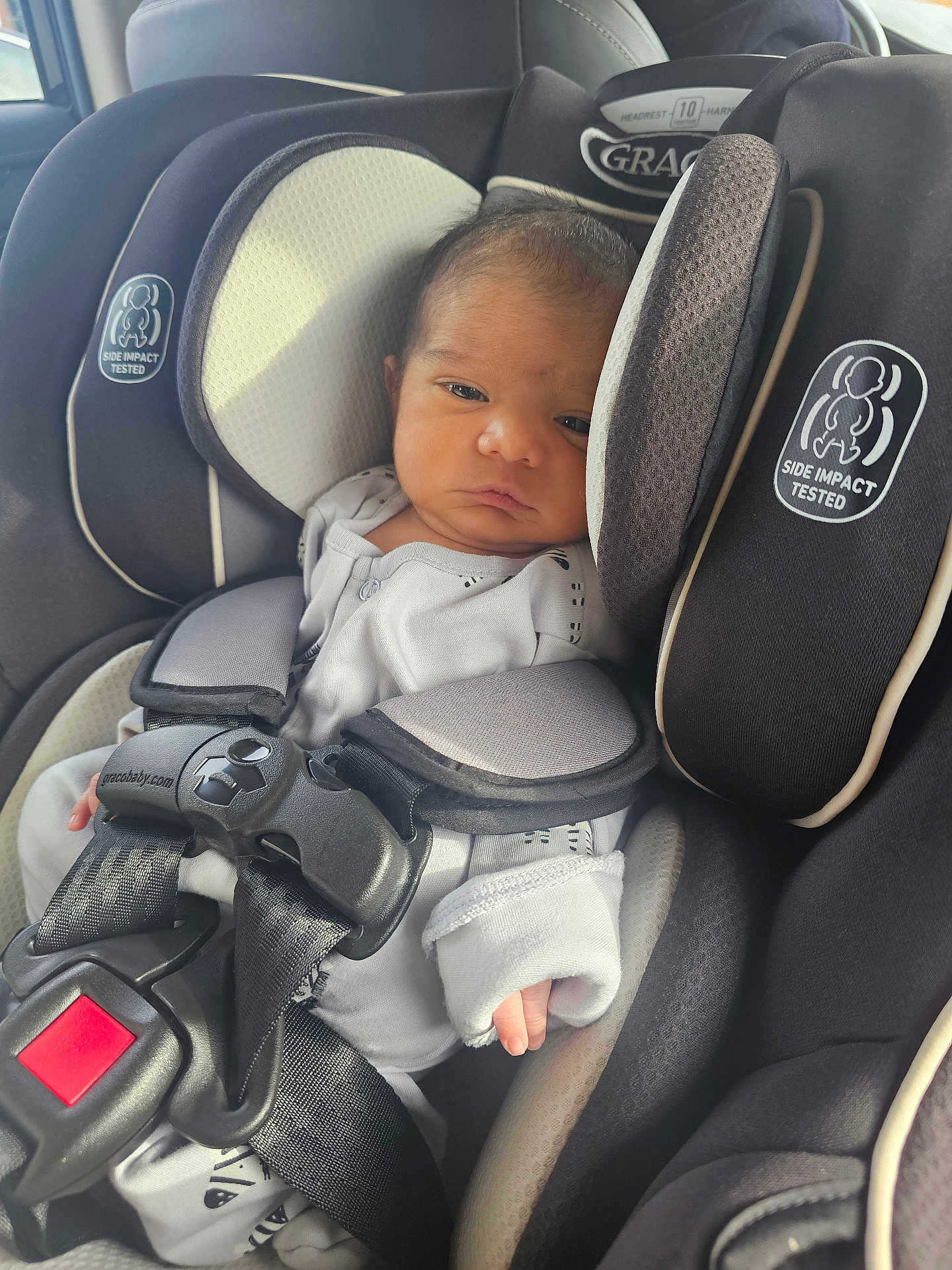 Jeyansh joined the competition — help win amazing prizes! baby, infant, car_seat, graco, seatbelt, white_clothing, newborn, child, safety, restraint, car_interior, seat, cute, small_hands, face, head_support, black, beige, infant_care, portrait