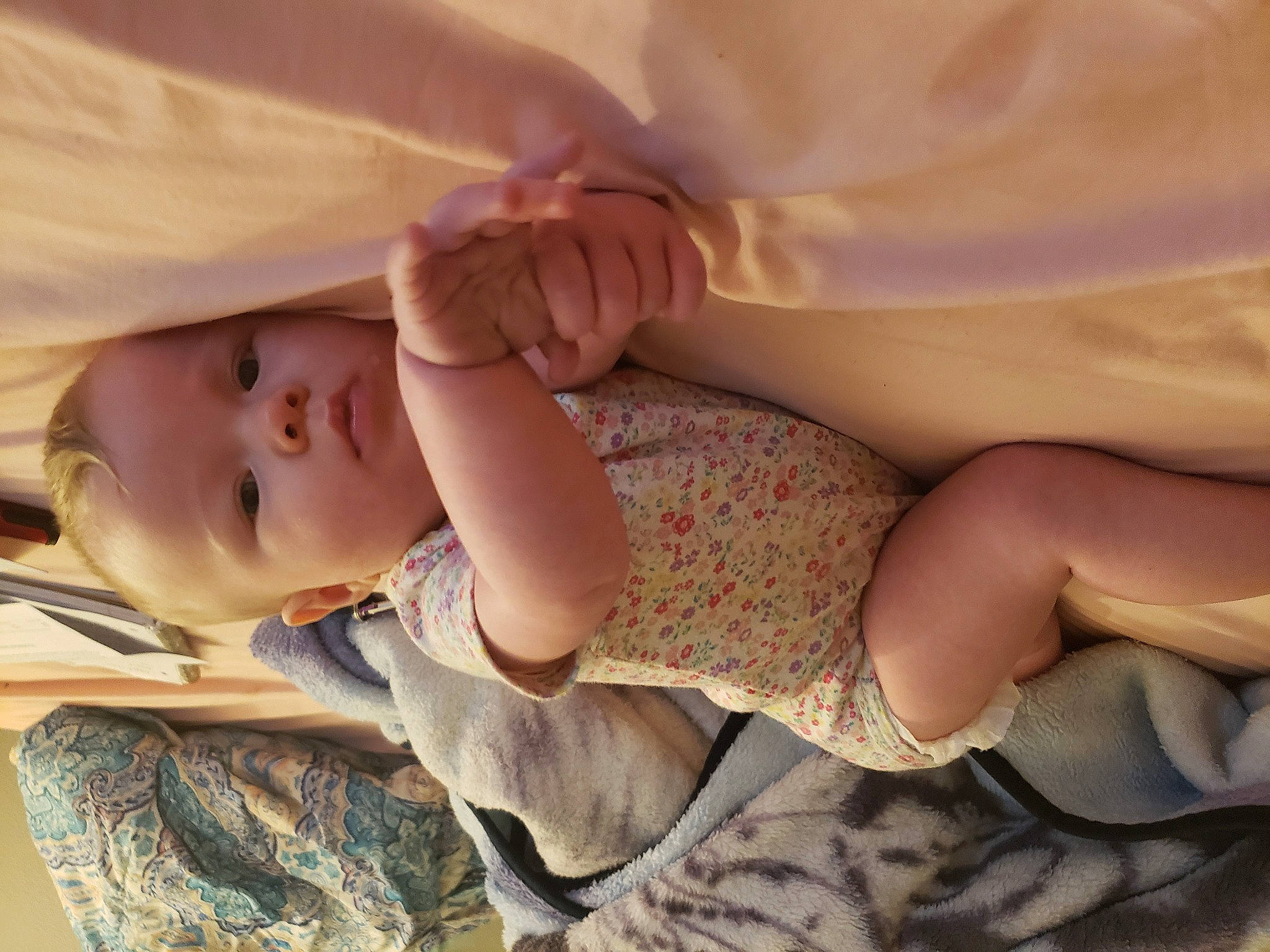 Phoebe is registered to the contest to win money with this photo: arm, baby, baby_toddler_clothing, cheek, comfort, dress, eye, facial_expression, finger, gesture, hand, head, human_body, leg, lip, nail, person, skin, sleeve, thumb