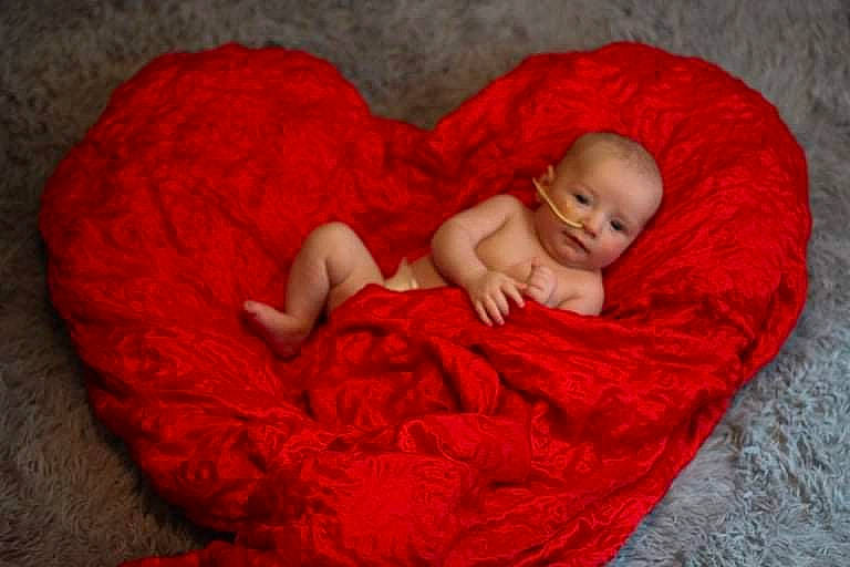 Ezio is registered to the contest to win money with this photo: baby, baby_toddler_clothing, cheek, child, comfort, eye, facial_expression, finger, grass, hand, head, human_body, linens, lip, mammal, person, skin, textile, toddler, vertebrate