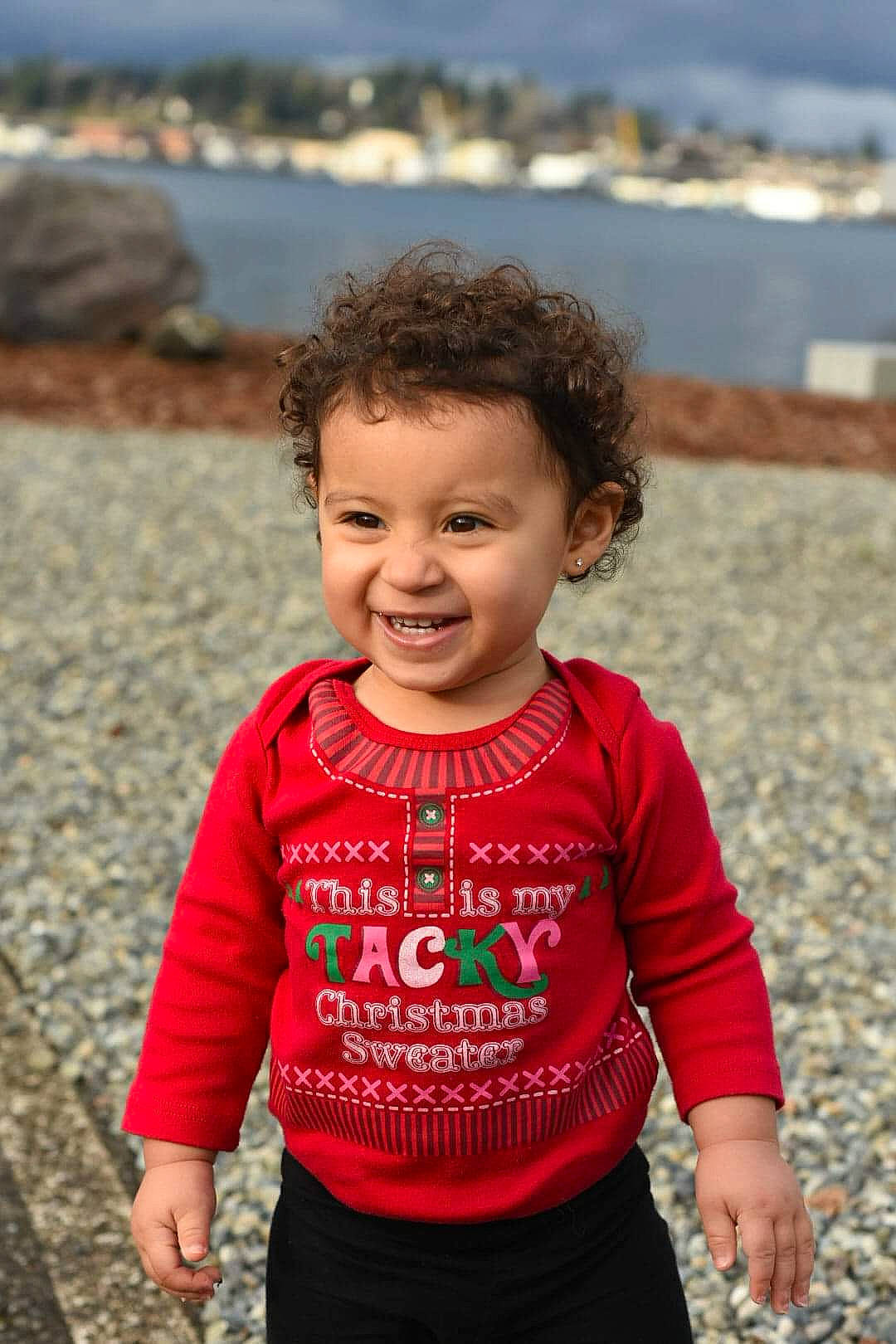 Isela is registered to the contest to win money with this photo: baby, beach, child, family, fun, joy, outerwear, pattern, people, person, photography, play, red, sand, sleeve, smile, sweater, t_shirt, toddler, top