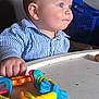 Marius participe au concours pour gagner de l'argent avec cette photo : baby, blue, child, closeup, colorful, curious, face, furniture, hand, head, high_chair, indoor, person, plastic, playtime, portrait, striped_shirt, table, toy, young_child