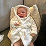 Arlo joined the competition — help win amazing prizes! baby, smiling, hood, robe, mittens, striped_clothing, pillow, cushion, carpet, indoor, person, infant, happy, cozy, soft_texture, clothing, portrait, child, cute, relaxed