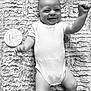 baby, infant, smiling, onesie, blanket, milestone_marker, two_months, lying_down, happy, cute, portrait, monochrome, texture, arm_raised, child, young_baby, human, soft, celebration, face