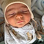 baby, sleeping, hat, bear_ears, bib, blanket, soft_texture, cute, peaceful, infant, clothing, closeup, face, headwear, resting, indoors, cozy, child, portrait, warm
