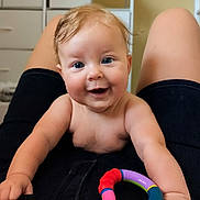 Spring is registered to the contest to win money with this photo: baby, smiling, blue_eyes, toy, indoor, person, child, happy, playful, hands, legs, clothing, face, infant, closeup, cute, skin, human, expression, joy