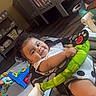 baby, infant, child, nursery, baby_seat, toys, crib, flooring, smiling, happy, indoor, furniture, playtime, colorful, cute, person, young_child, baby_clothes, seat, home