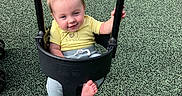 Daniel is registered to the contest to win money with this photo: baby, barefoot, chains, child, daylight, gray_pants, happy, infant, outdoor, park, play_surface, playground, playground_equipment, portrait, sitting, smiling, swing, swing_set, toddler, yellow_shirt