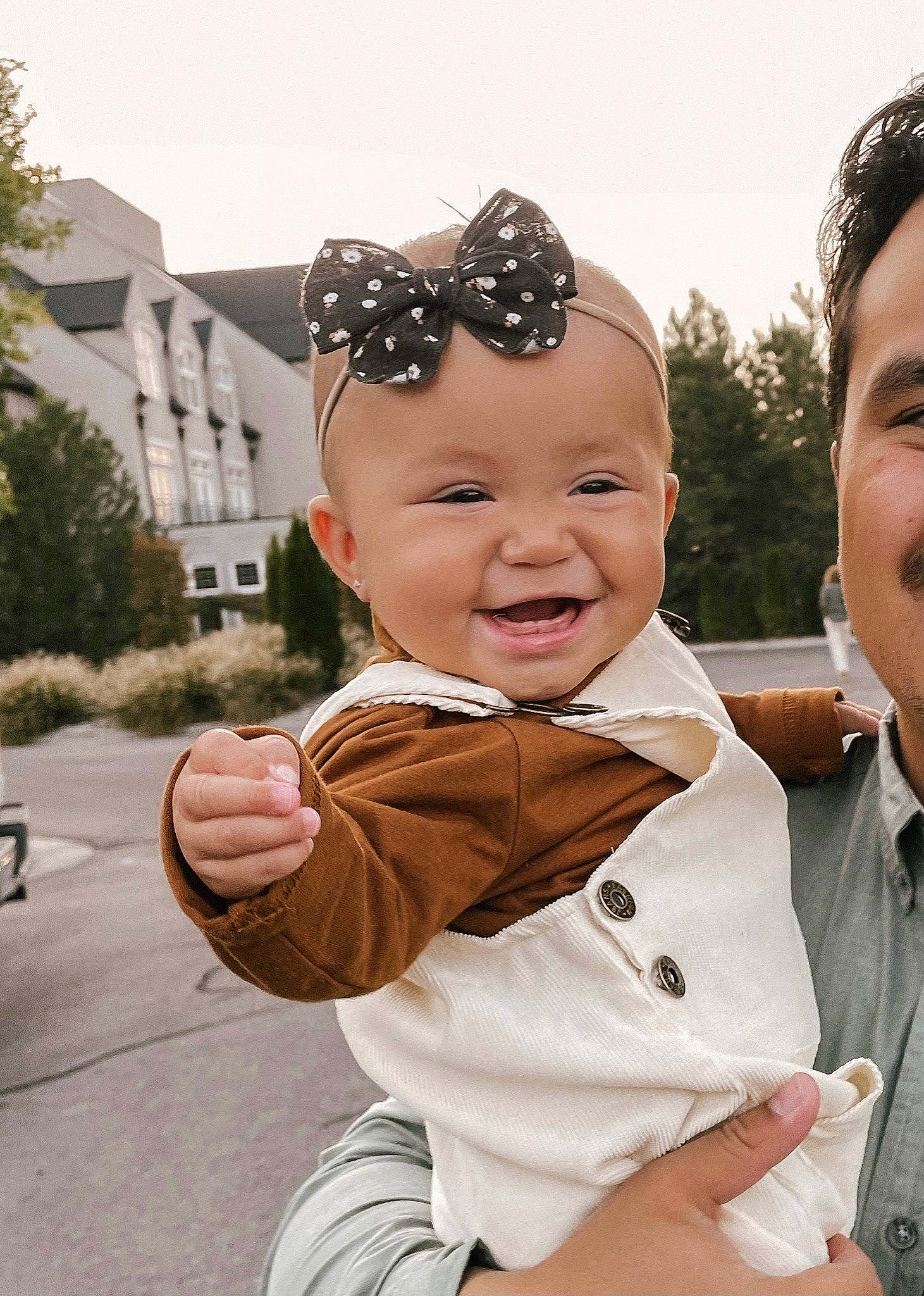 Jane is registered to the contest to win money with this photo: chin, cool, gesture, goggles, happy, head, headgear, headwear, human, interaction, mammal, person, plant, skin, sky, sleeve, smile, standing, toddler, tree