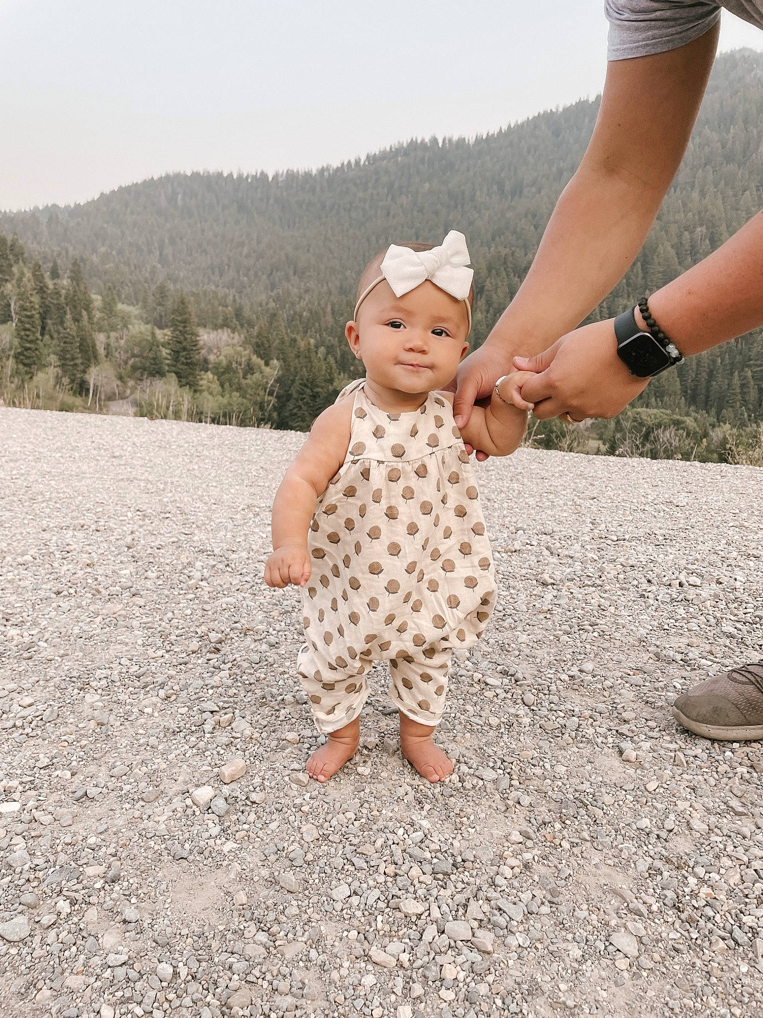 Jane joined the competition — help win amazing prizes! baby, baby_toddler_clothing, child, foot, gesture, grass, happy, headwear, human_leg, landscape, leg, mountain, people_in_nature, person, sand, sandal, shoe, sky, smile, toddler