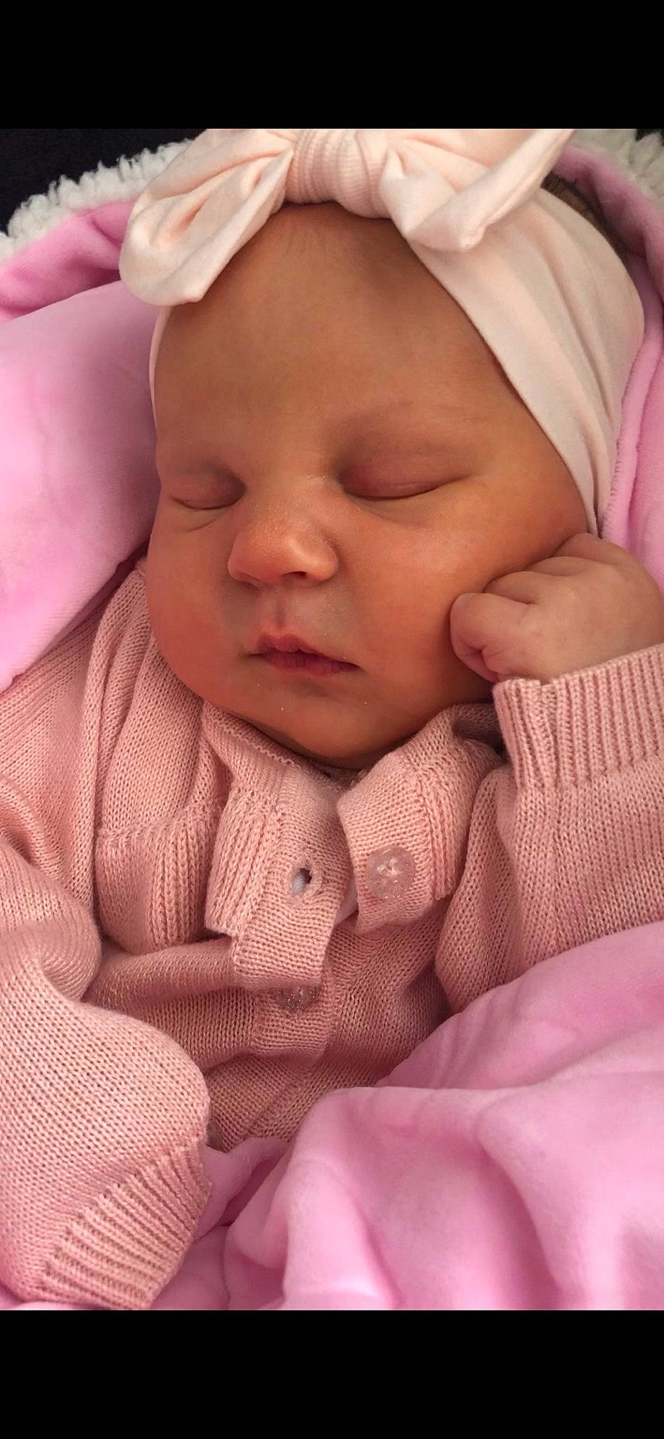 Esmae is registered to the contest to win money with this photo: baby, baby_toddler_clothing, cheek, chin, comfort, eye, eyebrow, finger, gesture, hand, head, human_body, lip, mouth, nose, person, pink, skin, smile, thumb