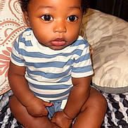 Camryn joined the competition — help win amazing prizes! baby, child, infant, curly_hair, striped_shirt, sitting, cross_legged, barefoot, blanket, pillow, indoors, wood_paneling, patterned, cute, portrait, large_eyes, skin, person, young, closeup