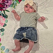 Violet is registered to the contest to win money with this photo: baby, infant, headband, bow, denim_shorts, floral_blanket, patterned_clothing, cute, child, lying_down, pink_flowers, green_leaves, soft_texture, skin, barefoot, small_hands, small_feet, portrait, indoors, happy_expression