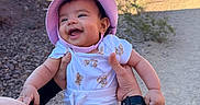 Janelle joined the competition — help win amazing prizes! baby, child, smiling, hat, outdoor, desert, lake, sunhat, happy, person, nature, blue_sky, teddy_bear_print, holding_hands, rocky_ground, landscape, daylight, casual_clothing, young_child, scenic_view