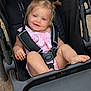 Ridlee Renee is registered to the contest to win money with this photo: child, toddler, stroller, smiling, blue_eyes, pigtails, pink_outfit, baby, seatbelt, outdoor, cute, happy, person, foot, hand, scraped_hand, casual, infant, portrait, playful