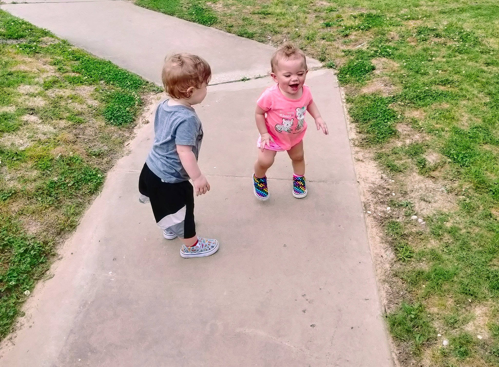 Kodie is registered to the contest to win money with this photo: asphalt, child, city, fun, grass, happy, landscape, lawn, leisure, person, plant, recreation, road_surface, sand, shorts, sidewalk, sneakers, soil, t_shirt, toddler