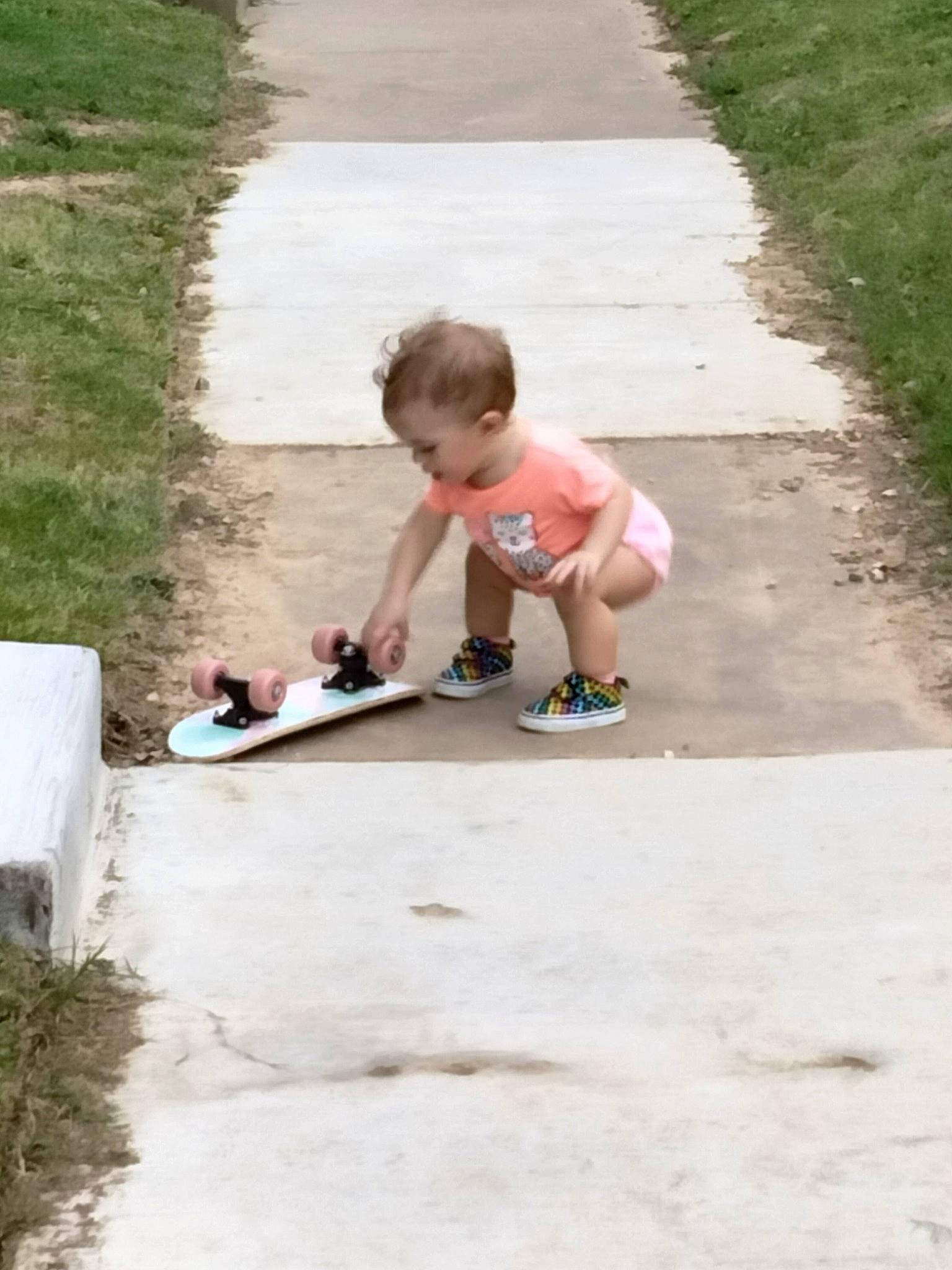 Kodie is registered to the contest to win money with this photo: asphalt, baby, child, concrete, driveway, flooring, fun, grass, lawn, leisure, person, plant, play, recreation, road_surface, shorts, sidewalk, sitting, soil, toddler
