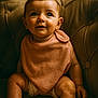 baby, bib, chair, child, curious, cute, face, hands, indoors, infant, legs, plush_chair, portrait, sitting, skin, smile, soft_texture, toddler, warm_lighting, young