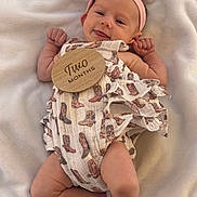 Hadley is registered to the contest to win money with this photo: adorable, baby, blanket, child, cowboy_boot_pattern, cute, foot, hand, happy, headband, infant, infant_clothing, lying_down, newborn, portrait, romper, skin, smile, soft_texture, two_months