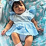 baby, infant, child, blue_dress, headband, blanket, cloud_pattern, pink_socks, cute, soft_lighting, indoors, portrait, chubby_cheeks, relaxed, young_child, clothing, fabric, resting, closeup, adorable