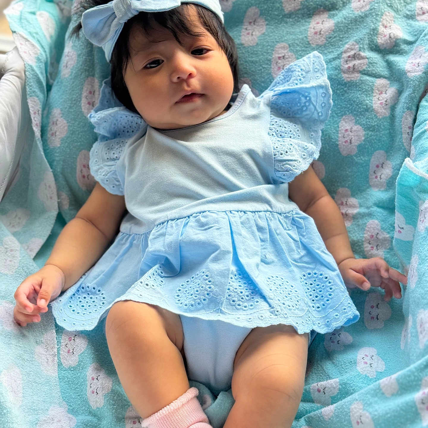 Aleia is registered to the contest to win money with this photo: adorable, baby, blanket, blue_dress, child, chubby_cheeks, closeup, clothing, cloud_pattern, cute, fabric, headband, indoors, infant, pink_socks, portrait, relaxed, resting, soft_lighting, young_child