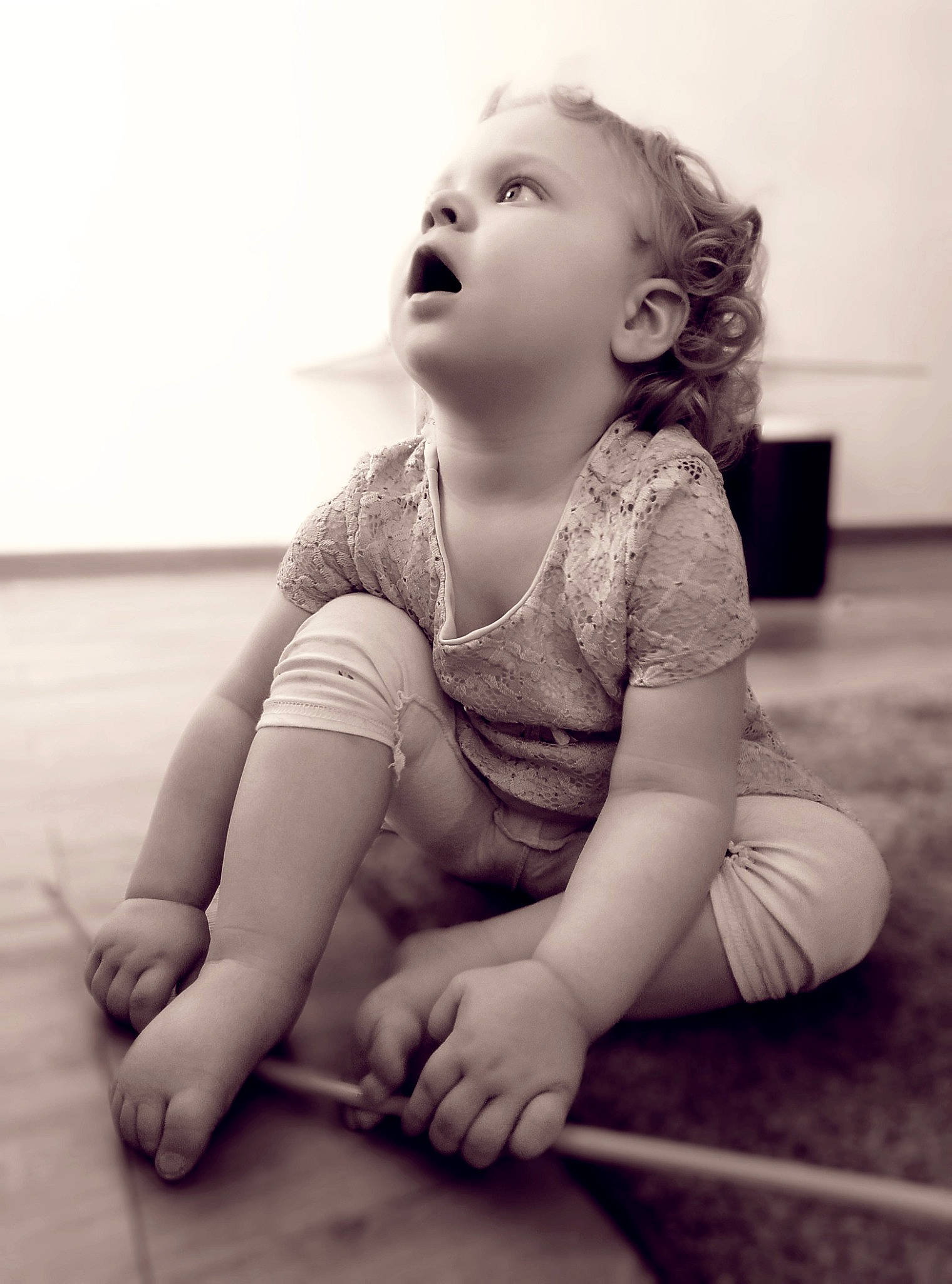 Kelyana participe au concours pour gagner de l'argent avec cette photo : arm, baby, beauty, black_and_white, cheek, child, eye, face, facial_expression, floor, head, lip, monochrome, person, photograph, sitting, skin, smile, standing, toddler