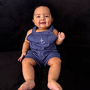 Hayes joined the competition — help win amazing prizes! baby, child, smiling, sitting, romper, blue_clothing, anchor_emblem, barefoot, chubby_cheeks, happy, face, portrait, indoor, couch, black_background, cute, person, infant, young_child, casual