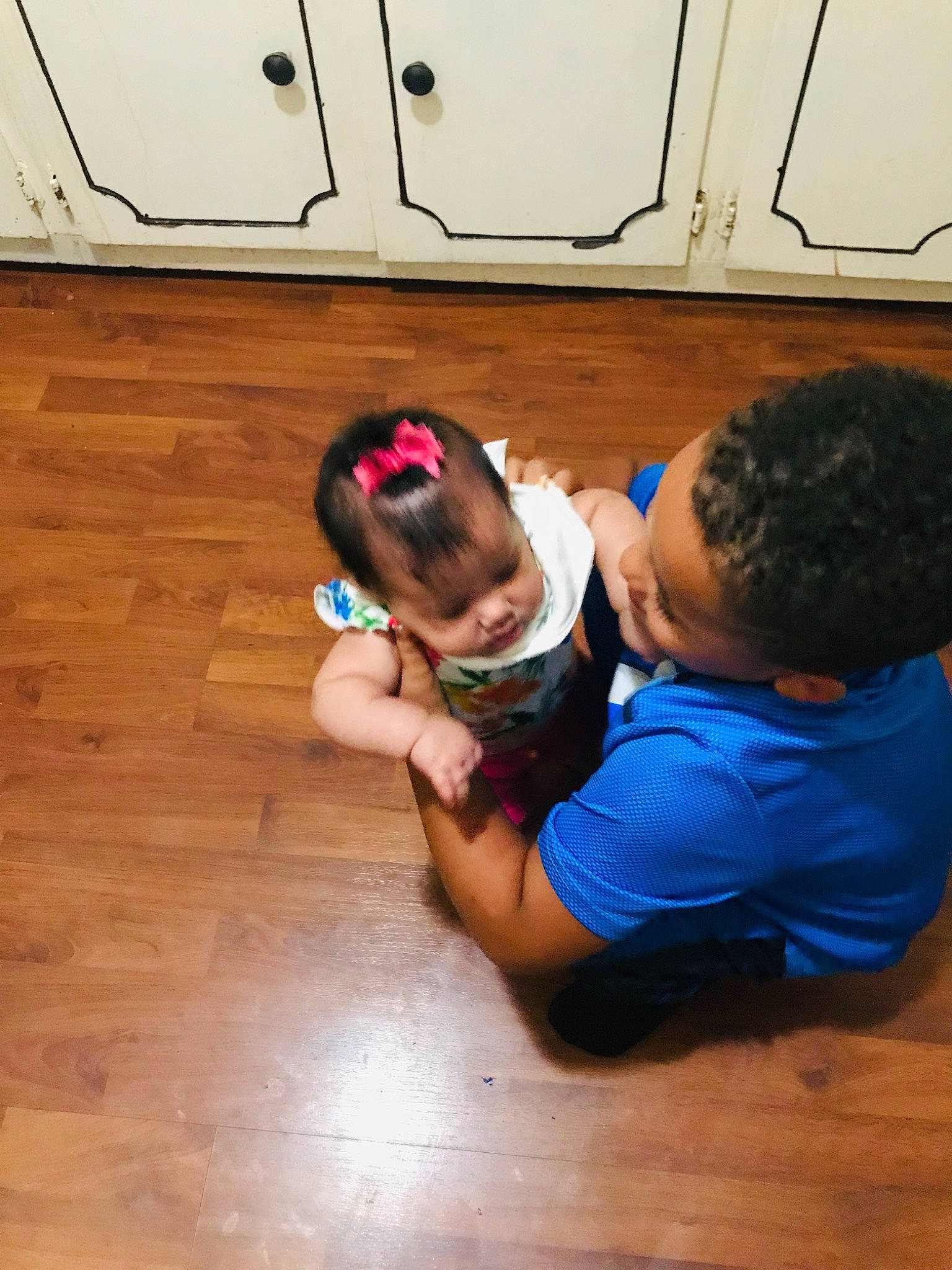 Trayvan is registered to the contest to win money with this photo: child, elbow, eyewear, floor, flooring, fun, happy, hardwood, laminate_flooring, leisure, person, play, recreation, room, sitting, t_shirt, toddler, varnish, wood, wood_flooring