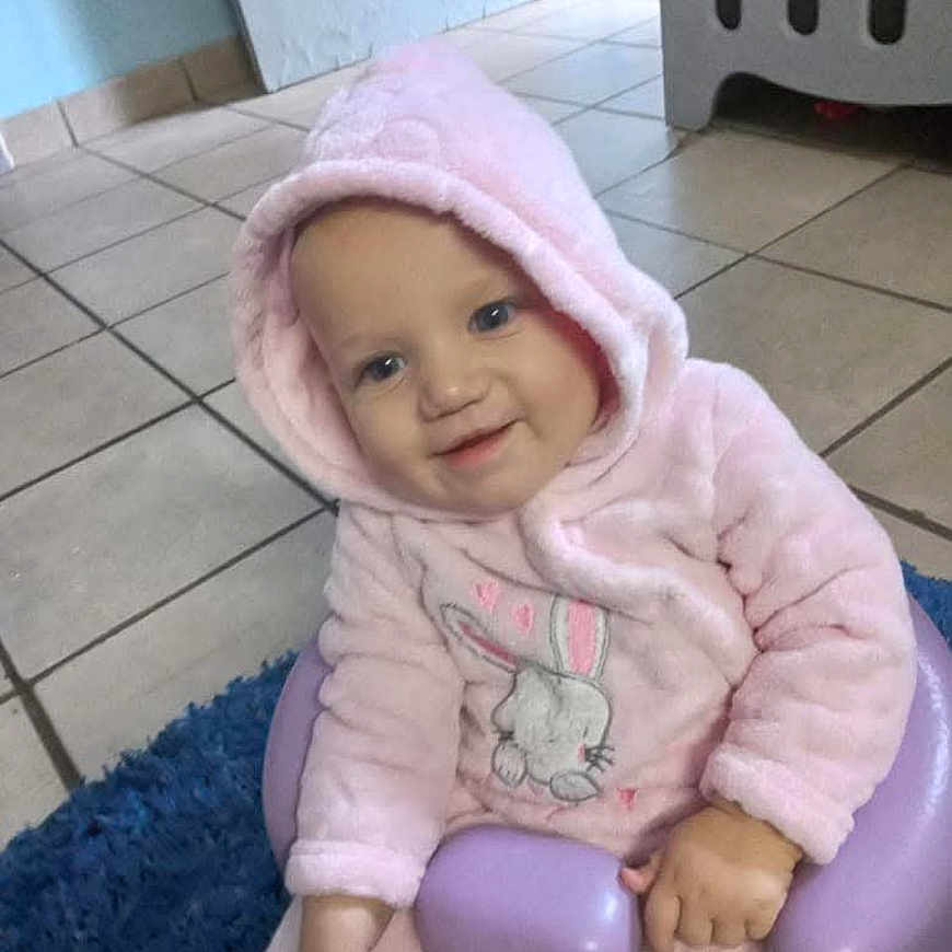 Vinay joined the competition — help win amazing prizes! baby, child, toddler, portrait, smiling, happy, pink_outfit, hooded_clothing, bunny_design, seated, chair, purple_chair, blue_rug, indoor, home, tiled_floor, laundry_basket, face, hands, social_media_screenshot