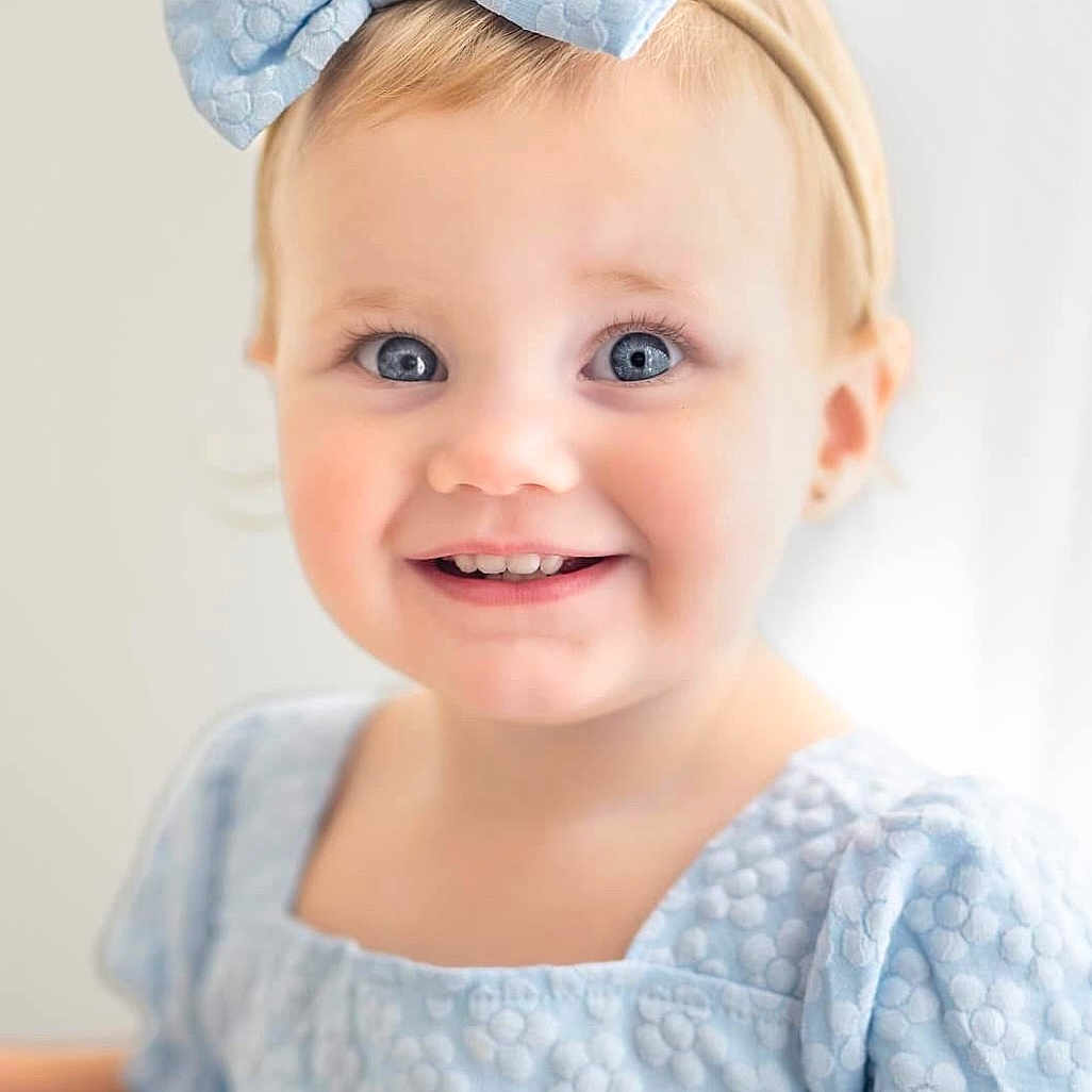 Brilee is registered to the contest to win money with this photo: apparel, baby, blonde_hair, blue_eyes, bow, child, closeup, cute, dress, face, fashion, happy, headband, indoor, person, portrait, smiling, soft_light, toddler, young_child