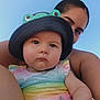 baby, child, adult, hat, frog_hat, colorful_clothing, outdoor, sky, portrait, face, person, smile, skin, arm, summer, cute, closeup, headwear, happy, family
