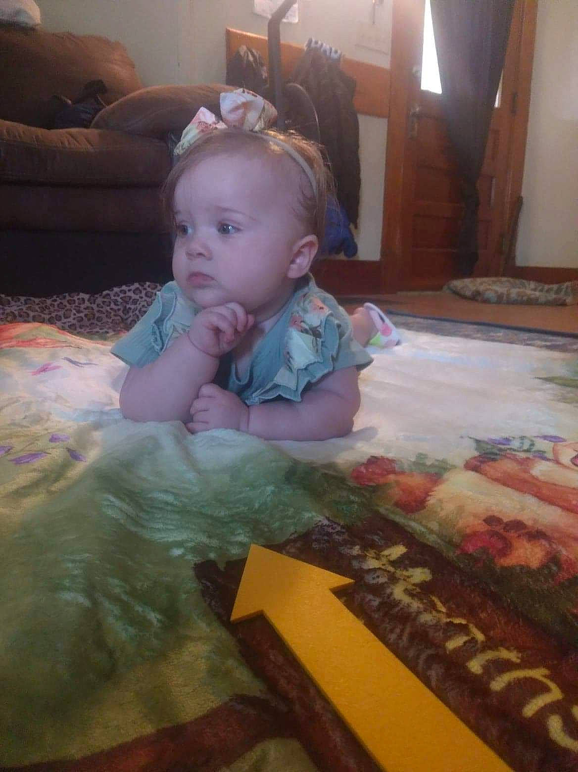 Harleigh is registered to the contest to win money with this photo: art, baby, baby_products, baby_toddler_clothing, cheek, child, comfort, floor, flooring, fun, hardwood, linens, person, personal_protective_equipment, play, room, sitting, textile, toddler, visual_arts