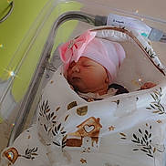 Lydia a rejoint le concours — aidez-le/la à gagner de superbes lots ! newborn, baby, sleeping, blanket, pink_hat, bow, hospital_bassinet, patterned_blanket, cute, peaceful, infant, wrapped, resting, soft_light, sparkles, indoors, person, face, head, cozy